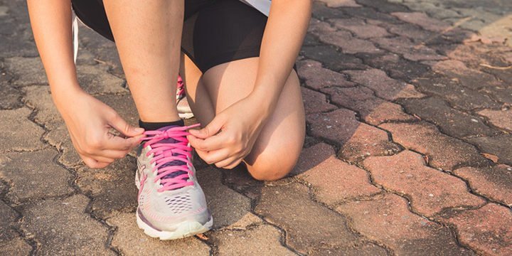 Eine Läuferin bindet sich die Schuhe