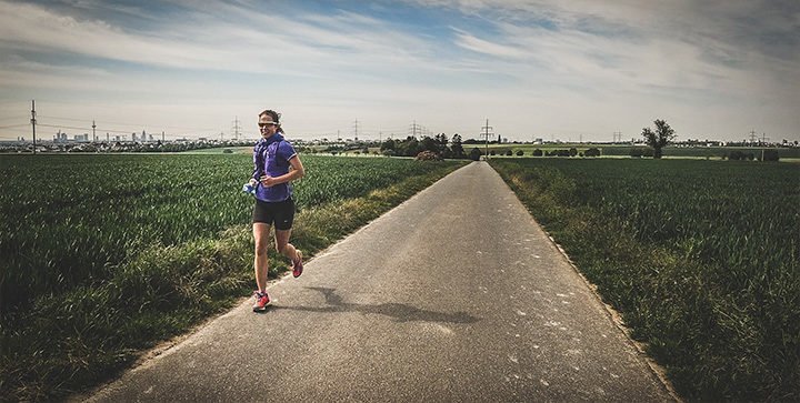 Katrin läuft auf einem Weg durch die Felder