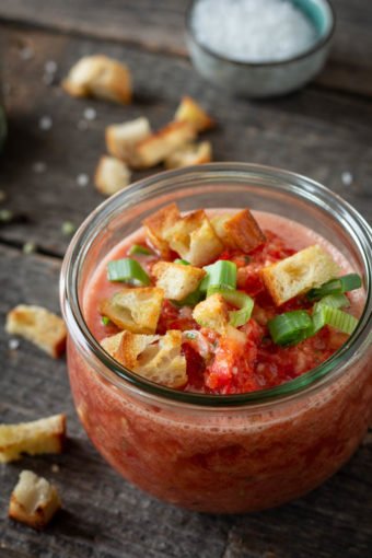 Eine Gazpacho mit Röstbrot und Frühlingszwiebeln