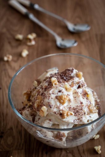 Eine Schale mit selbstgemachtem veganen Bananeneis auf einem Holztisch mit zwei Löffeln