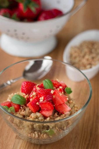 Eine Schale Quinoaporridge mit frischen Erdbeeren und gerösteten Mandeln