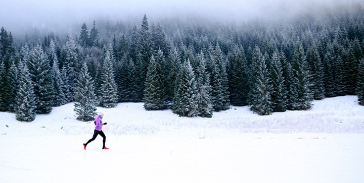 Eine Läuferin läuft durch eine Winterlandschaft