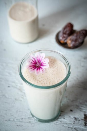 Ein Glas Reis-Kokos-Drink auf einer hellen Tischplatte