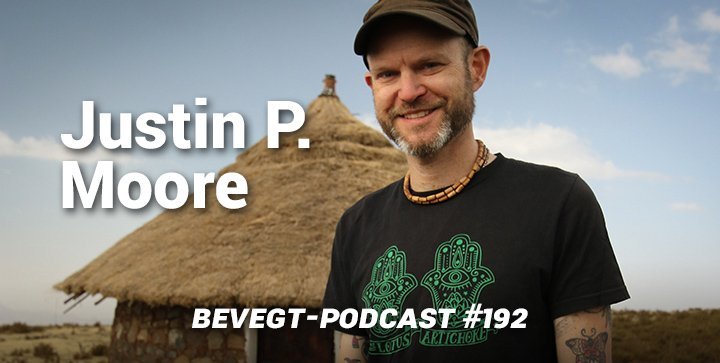 Der vegane Kochbuchautor und Weltreisende Justin P. Moore steht vor einer Strohhütte