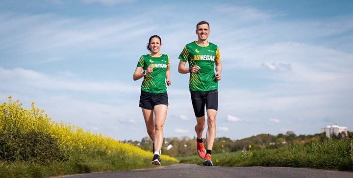 Katrin und Daniel laufen neben einem Rapsfeld