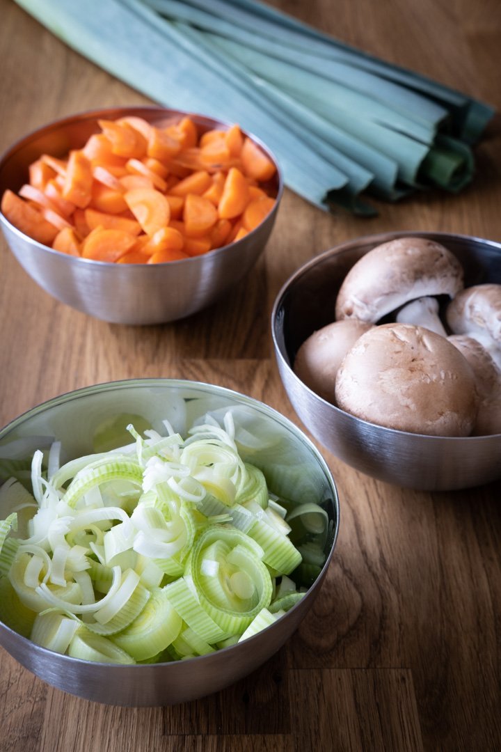 Drei Schalen mit Lauchringen, Champignons und Karottenwürfeln