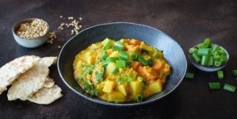 Ein Teller veganes Kartoffel-Linsen-Curry mit Pfannenbrot
