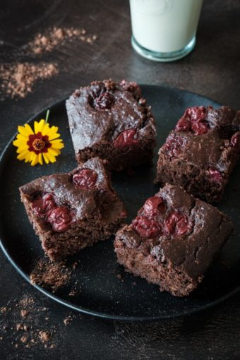 Veganer Zucchini-Schoko-Kirsch-Kuchen auf einem dunklen Teller