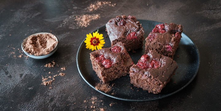 Veganer Zucchini-Schoko-Kirsch-Kuchen auf einem dunklen Teller