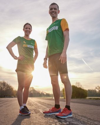 Katrin und Daniel stehen in ihren RUN VEGAN Laufshirts vor der aufgehenden Sonne