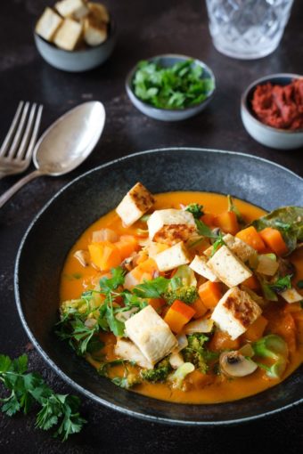 Ein veganes rotes Thai-Curry mit Kürbis, Tofu und buntem Gemüse