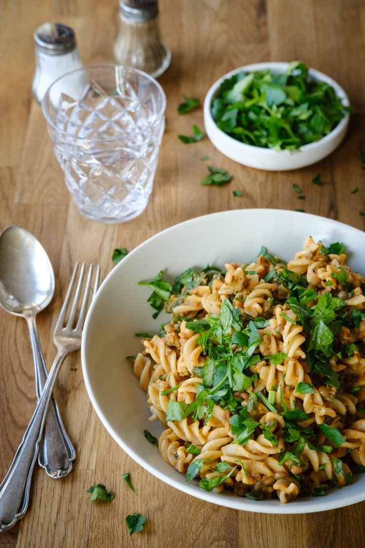 Ein Teller vegane Berglinsen-Pasta mit cremiger Erdnuss-Spinatsoße