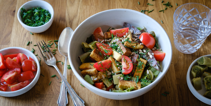 Ein grüner Salat mit Tomaten, Maultaschen und Tofu