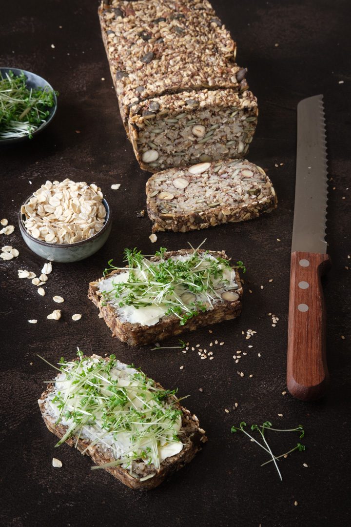 Zwei Scheiben selbstgebackenes, glutenfreies Saatenbrot mit veganer Butter und Kresse