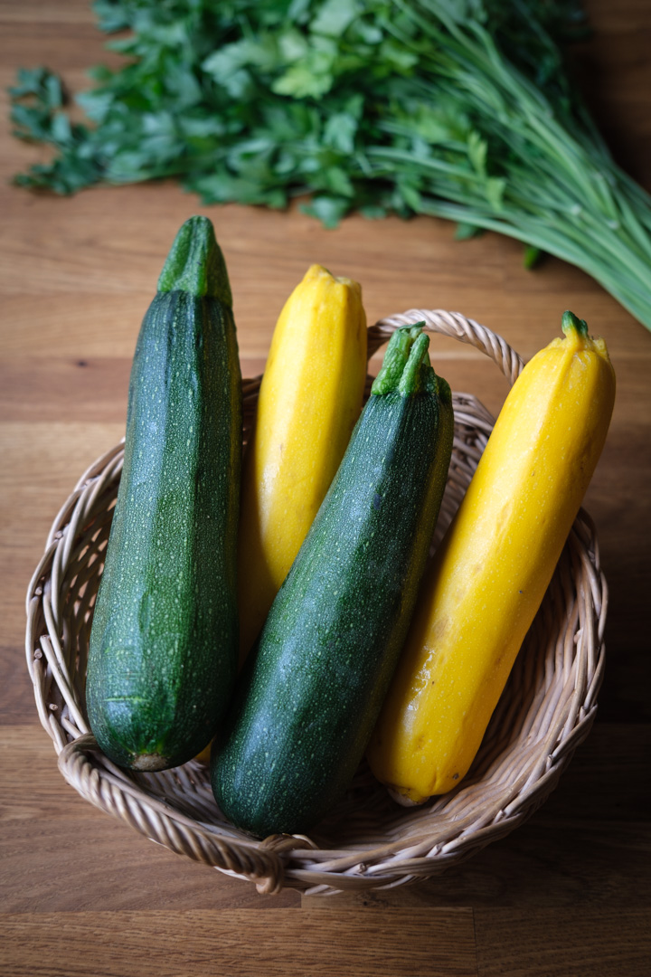 grüne und gelbe Zucchini in einem Holzkörbchen