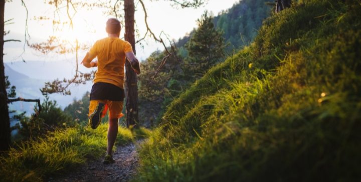 Ein Mann läuft auf einem Trail im Wald