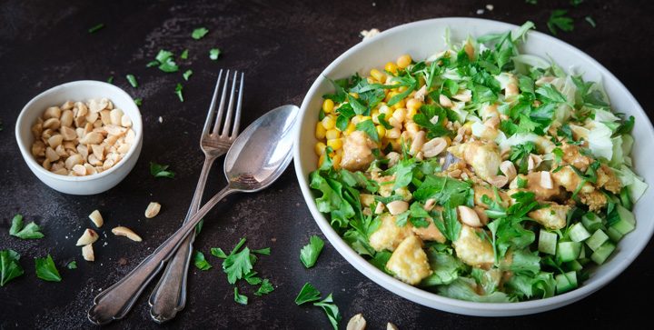 Eine grüne vegane Sommerbowl mit Glasnudeln, Tofu und Erdnusssoße
