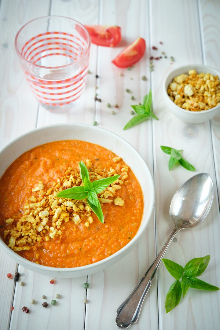 Eine Schüssel gebackene Tomatensuppe mit Tofutopping und Basilikum