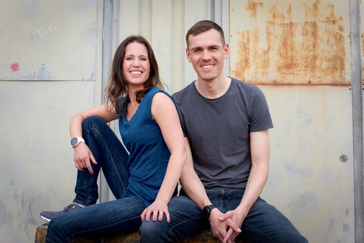 Katrin und Daniel sitzen vor einer grauen Wand