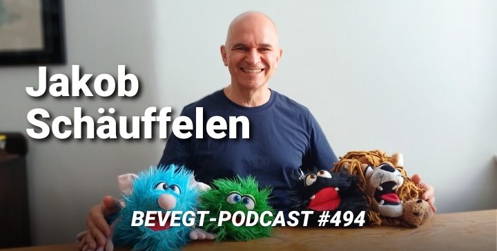 Jakob Schäuffelen sitzt hinter seinen Handpuppen an einem Tisch