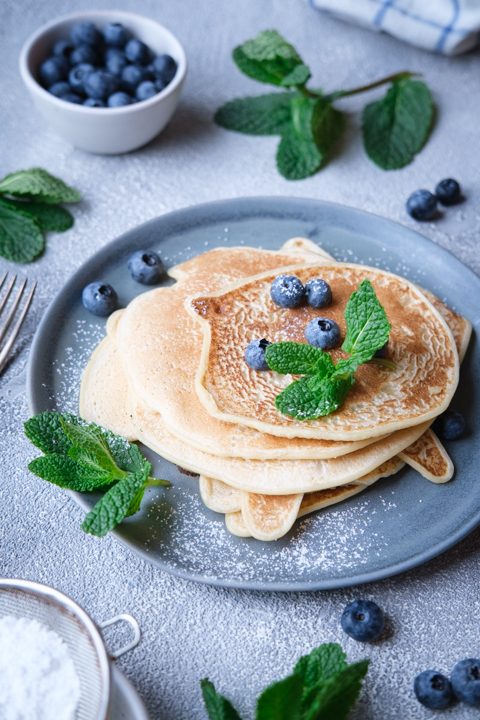Vegane Pfannkuchen aus nur zwei Zutaten, dekoriert mit Heidelbeeren und Minzblättern