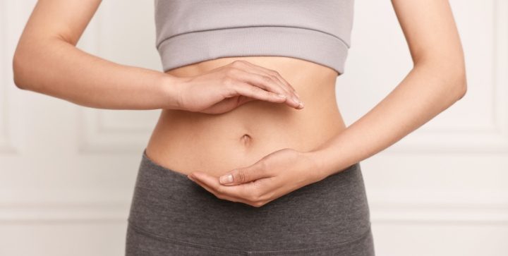 Eine Frau hält beide Hände vor ihren Bauch