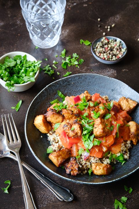 Ein Teller Quinoa mit Tomatensugo, Umami-Tofu und frischer Petersilie